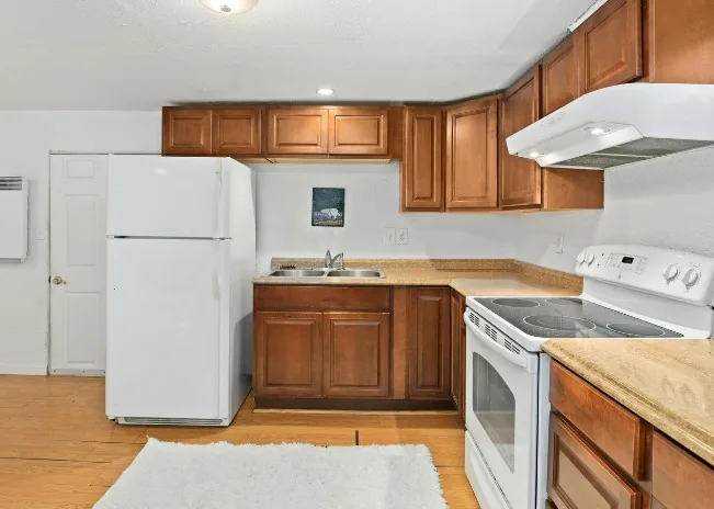 Cocina con armarios en madera de caoba y electrodomésticos blancos en Burgos