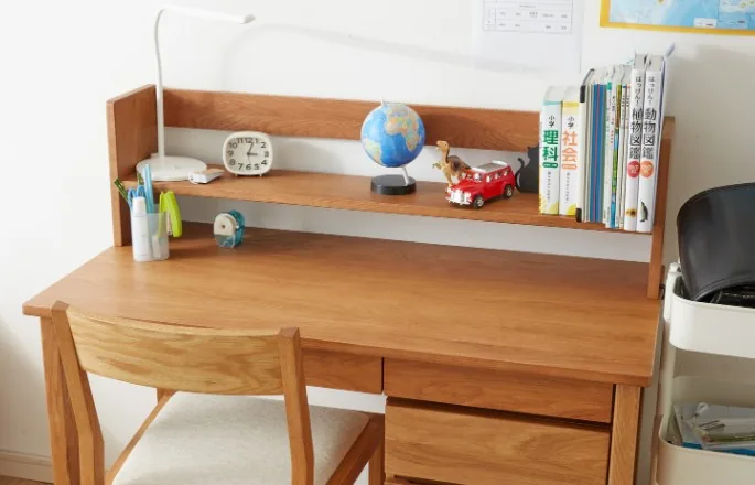 Escritorio infantil en madera de roble claro con estantería superior, libros y silla a juego en Burgos