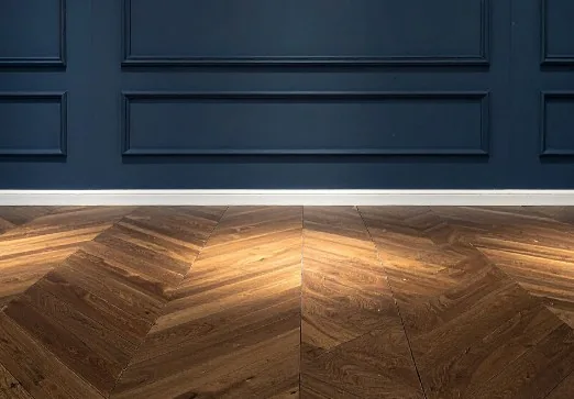 Primer plano de suelo de madera en espiga (chevron) tono castaño con pared de friso azul marino en Burgos