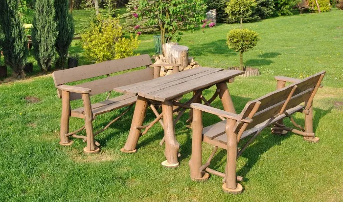 Zona de comedor de jardín bajo cenador de madera en una finca de la provincia de Burgos
