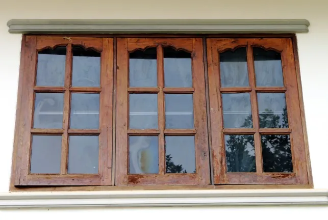 Triple ventana de madera de roble con remate en arco en la fachada de un edificio histórico de Burgos