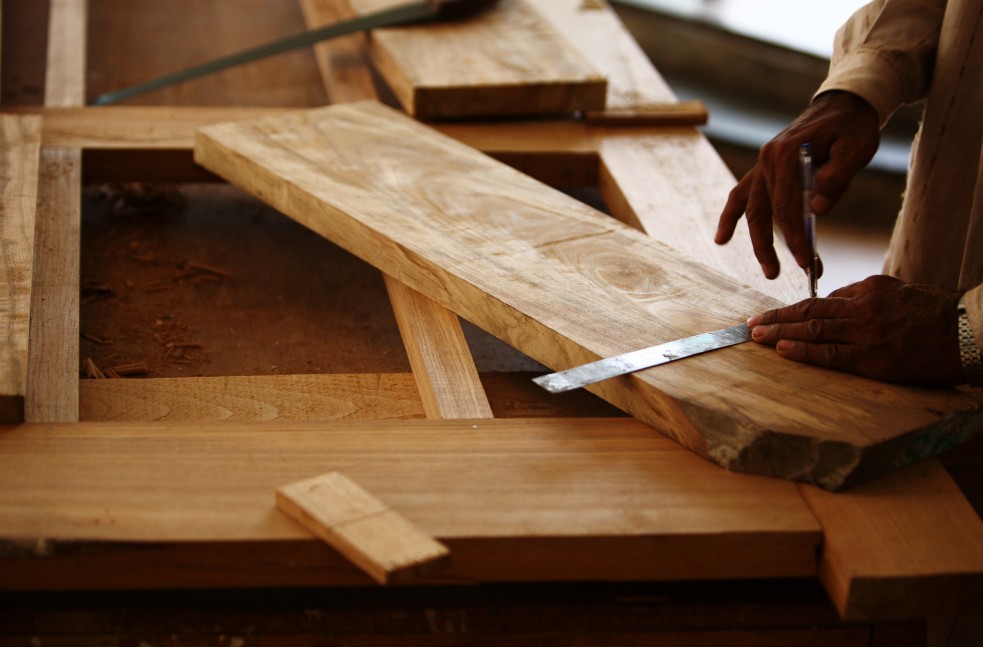 Detalle de medición de precisión sobre tabla de madera en nuestro taller